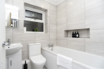 Modern bathroom with bath, fresh towels and complimentary toiletries