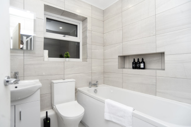 Modern bathroom with bath, fresh towels and complimentary toiletries
