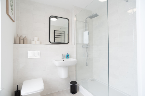 Modern en-suite bathroom with walk-in shower and complimentary toiletries.