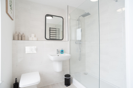 Modern en-suite bathroom with walk-in shower and complimentary toiletries.