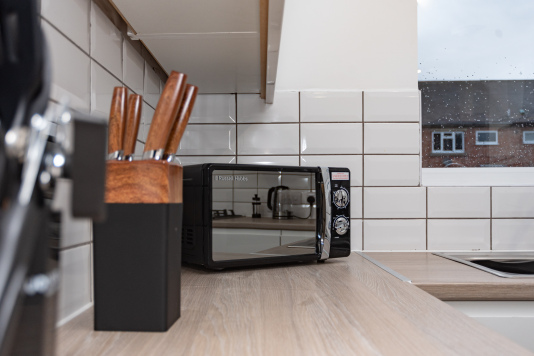 Kitchen sideboard stocked with all utensils and a microwave — perfect for quick, on-the-go meals during your stay.