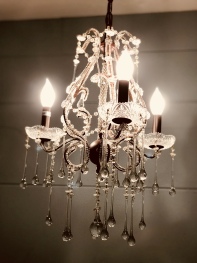 This teardrop crystal chandelier is fitting for this trunk room where Elisabeth painted.
