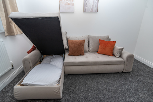 Luxury sofa bed sleeping two, fully dressed with fresh linens — offering stylish, comfortable extra sleeping space for your stay.