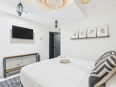 Another angle of the primary bedroom, showing the thoughtful art and warm lighting.