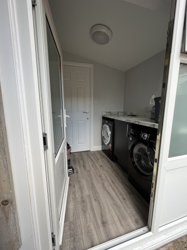 Laundry room - With washing machine, dryer, iron & ironing board and clothes horse