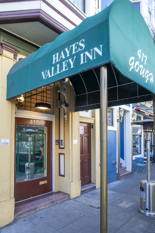 A green awning with white lettering over a hotel entrance.