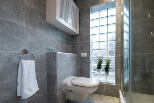 The fully tiled bathroom with a large, luxurious bath, separate shower enclosure, wash basin, heated towel rail and W.C.