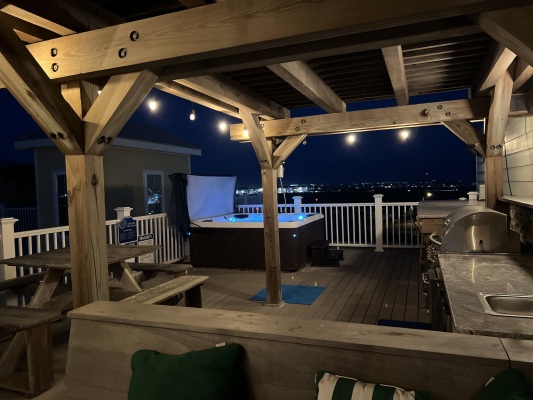 Rooftop area in the evening, there are party lights and bluetooth speakers