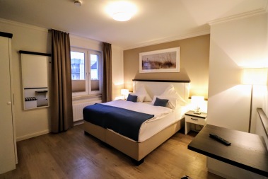 Schlafzimmer mit Sitzmöglichkeit, TV und Kleiderschrank