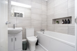 A bright, hotel-style master bathroom fully stocked with essentials for a comfortable stay.