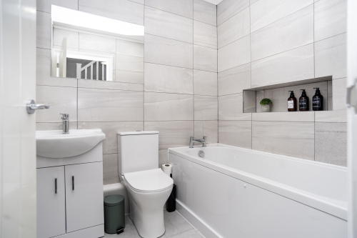 A bright, hotel-style master bathroom fully stocked with essentials for a comfortable stay.