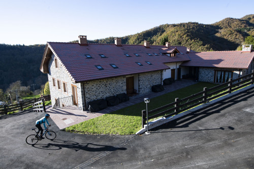 Ciclista saliendo de los Apartamentos Los Picos de Europa (Colio, Valle de Liébana)