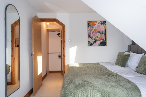 Bedroom 6 (first floor) features a fixed king-size bed, set as a king to best suit the room layout. Finished with cosy hotel-quality linens and towels, plus a walk-in wardrobe and access to the master bathroom.