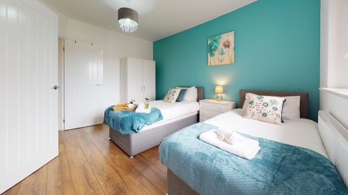 SRK Serviced Accommodation - Bedroom 2 with bedside cabinet, lamp and beautiful colours throughout the apartment. Master Bedroom - Bedside cabinet, lamp, wardrobe. and ensuite