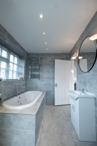 The fully tiled bathroom with a large, luxurious bath, separate shower enclosure, wash basin, heated towel rail and W.C.