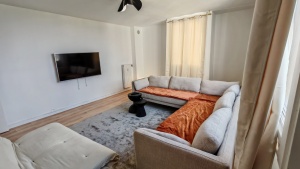 Salon cosy avec TV écran plat et grand canapé confortable