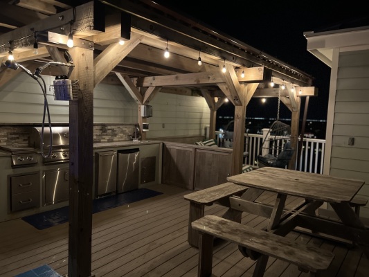 Rooftop has dining area, kitchen, lounge area with swing chairs and propane fire table. 