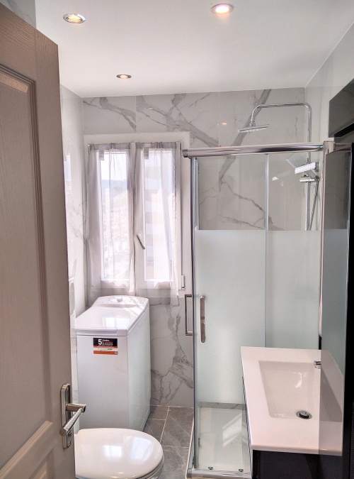 Salle d'eau avec machine à laver et toilettes