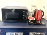 In each room: Microwave, plates, bowls, cutlery, tea, coffee, sugar, biscuits, kettle, mugs, drinking glasses