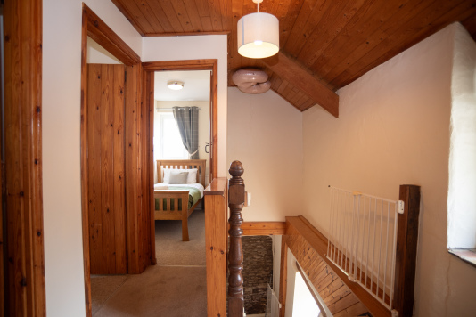 Welcoming Upstairs Landing - Original pine detailing and a solid wooden banister lead to the bedrooms upstairs, giving the whole space a warm, country-house feel.
