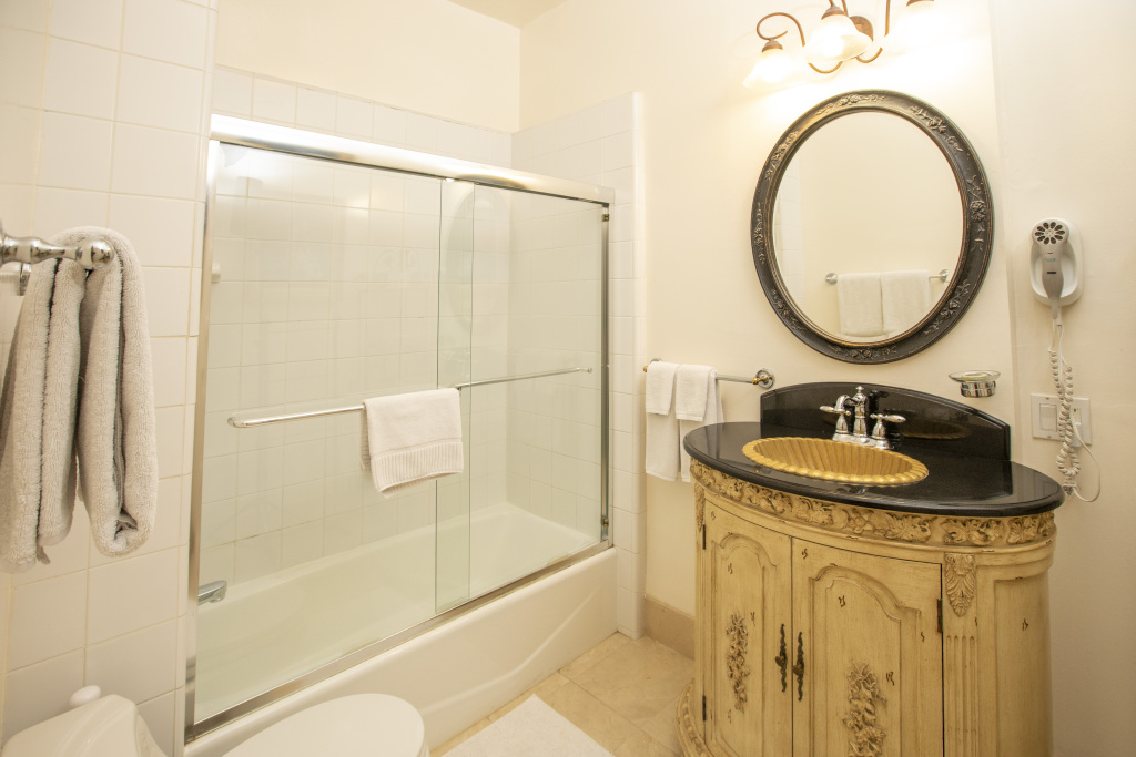 A bathroom with a shower, sink, and mirror