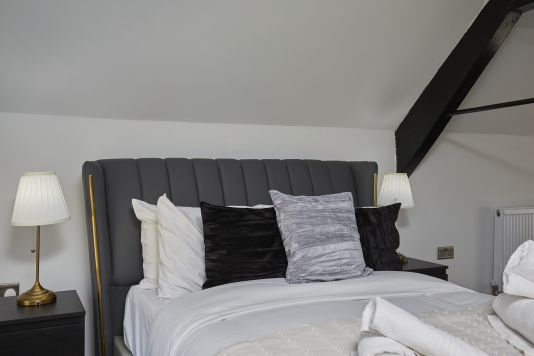 Sleep easy in this spacious double bedroom with soft linens and a relaxing ambience.