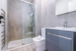 A modern bathroom featuring a shower, a towel rack, and a radiator for added comfort.
