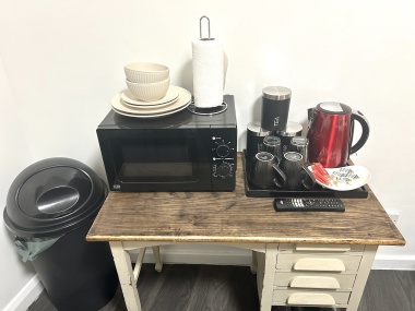 In each room: Microwave, plates, bowls, cutlery, tea, coffee, sugar, biscuits, kettle, mugs, drinking glasses