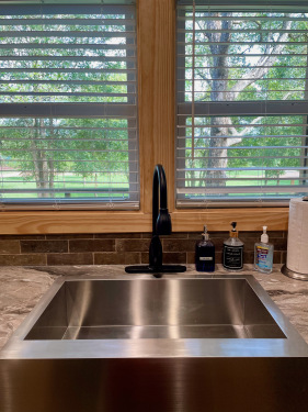 Enjoy the park-like setting from the farmhouse kitchen sink at the Wyldwood Cabin!