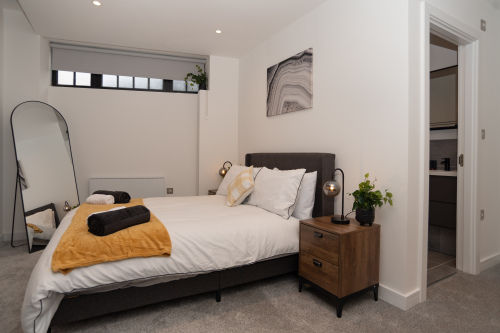 A beautifully styled double bedroom with a private en suite, ample storage and wardrobes, finished with hotel-style bedding and towels for a perfectly comfortable stay.