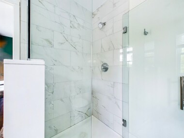 Full Bathroom 2 features a luxurious walk-in shower with marble-style tile and sleek glass doors. The modern design and quality fixtures create a spa-like ambiance.