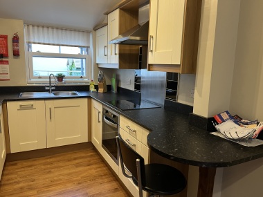 Kitchen with appliances and compact breakfast bar