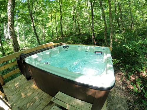 Hot tub on wooden deck with forest view