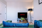 Comfortable living room with a TV and cosy sofa, perfect for relaxing after a day of exploring.