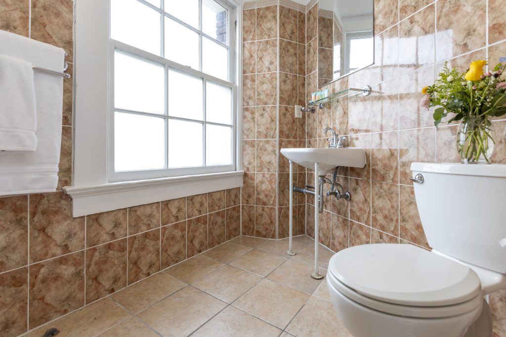 A bathroom with a toilet, sink, and window