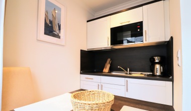 Küchenzeile mit Kaffeemaschine, Mikrowelle und Kochplatten