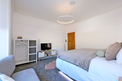 First floor bedroom spacious with storage, seating and Smart Tv and ambient lighting as well as tread bed LEDs