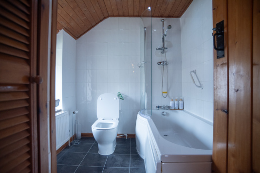 Bathroom with Bath & Overhead Shower - Full bath, overhead shower and complimentary luxury toiletries provided, perfect for a proper soak after a day on the coast.