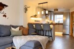 A stylish open-plan living space featuring a cosy lounge, dining area and modern kitchen, creating the perfect setting to relax, entertain and feel at home.