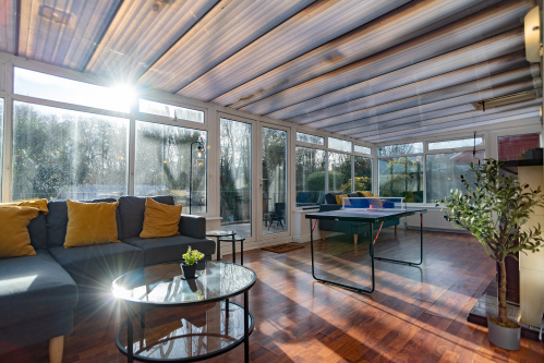 Games room conservatory with comfortable seating and a ping-pong table, offering a relaxed space for family fun and downtime.