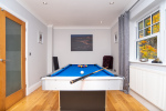 Games room with a full-size pool table, ideal for families, hen and stag groups, and coworkers looking to unwind during work breaks.