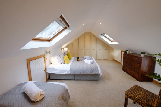 The large upper bedroom has a Super King double bed and also a single bed. The Super King bed can also be configured as two full-size single beds if required, giving guests the option of three single beds in this room.