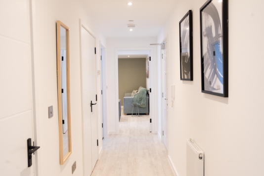 Bright entryway hallway connecting the bedrooms, bathrooms, living space and kitchen.