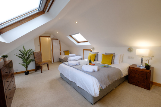 The large upper bedroom has a Super King double bed and also a single bed. The Super King bed can also be configured as two full-size single beds if required, giving guests the option of three single beds in this room.