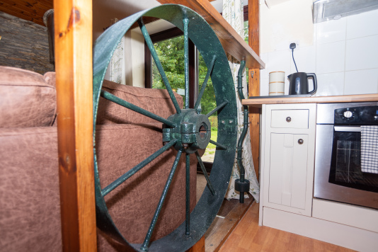 The Mill Wheel Frames Your Kitchen - The original cast iron wheel sits between the living area and kitchen, a piece of Devon mill history right at the heart of your home for the week