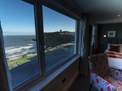 Sit back and enjoy the view from large picture window in The Sea View Penhouse Suite