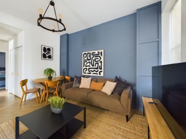 Namaste. Be welcomed with a tea set in this serene living room, featuring calming blue tones, a cozy sofa, and soft natural light. Perfect for unwinding, journaling, or enjoying peaceful moments in this tranquil, zen-inspired retreat.