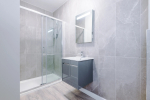 A modern bathroom featuring a shower, a towel rack, and a radiator for added comfort.