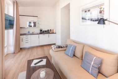 Wohnbereich mit Schlafcouch, TV und Küchenzeile 