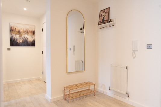 Welcoming entrance area with mirror and space for coats and shoes.